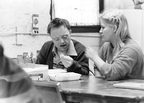 A young man studies flash cards with the help of a young woman